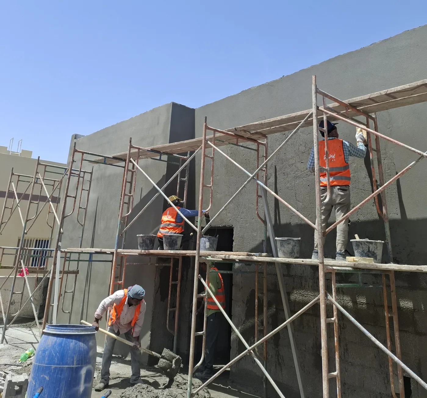 Benaa Contracting crew plastering the external walls of a villa during black construction