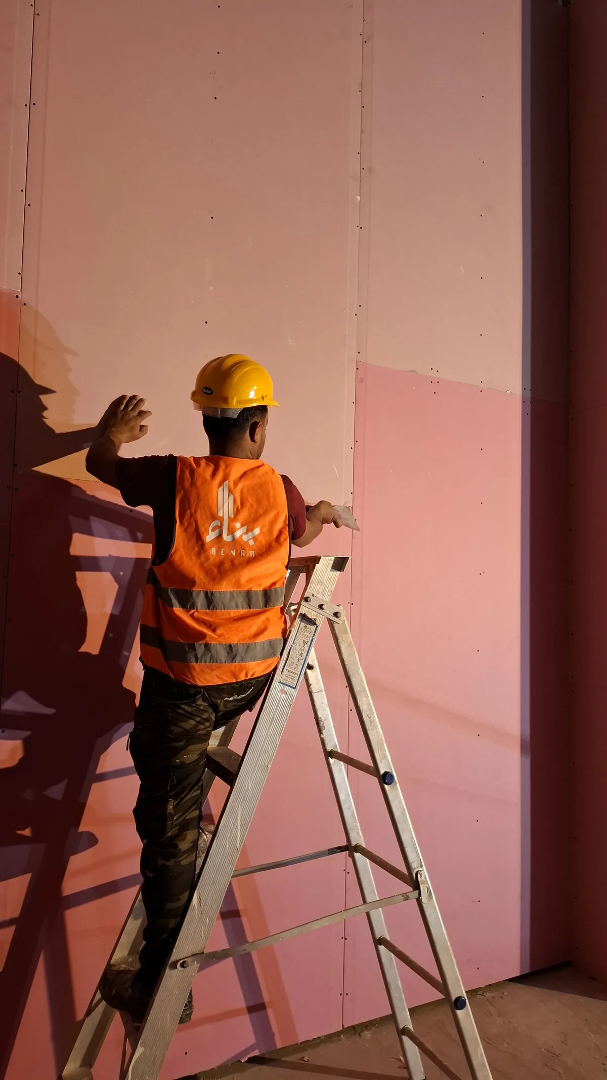Benaa Contracting installer fixing gypsum board wall cladding in a shopping mall
